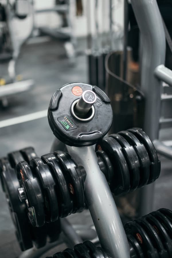 Weight plates stacked on a rack in a gym, one marked 2.5 kg in orange